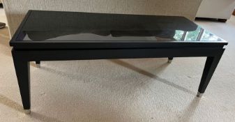A black coffee table with glass top and chrome caps to legs (H46cm W120cm D50cm)