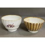 A gilded Worcester tea bowl and a Worcester 1800-1809 tea bowl