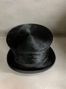 A silk top hat in leather carry case