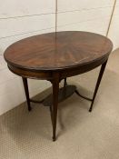 An oval centre table or occasional table on square tapered legs joined by an under tier