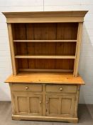 A Welsh dresser with open shelves to top and cupboards under (H81cm W132cm D49cm)
