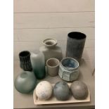 A selection of various blue and grey ceramics along with decorative spheres and vases.