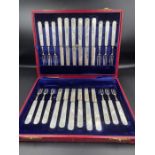 A cased silver and mother of pearl twelve place setting dessert cutlery set of knives and forks by