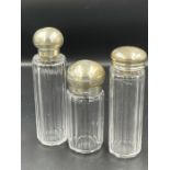 Three silver lidded glass bottles