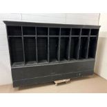 A large wooden school locker/coat wall rack, each pigeon hole has a coat hook and shelf above on a