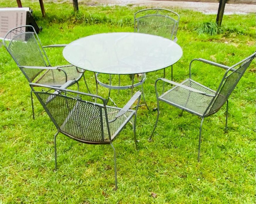 A metal garden circular table and four mesh design garden chairs