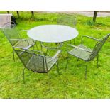 A metal garden circular table and four mesh design garden chairs