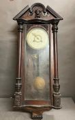 A carved wall clock with pendulum AF