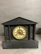 A black slate clock with columns to sides