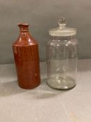 A glass lidded jar and an earthenware bottle