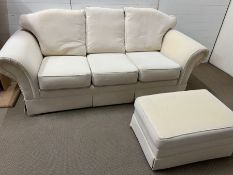 Three seater white sofa and a foot stool