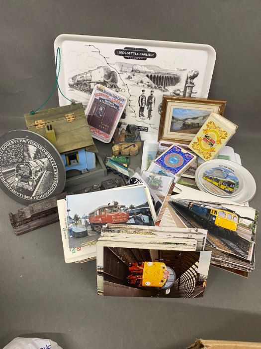 A large selection of various railway collectables, clock, model of train, postcards, mats, playing