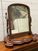 A mahogany toilet mirror or dressing mirror or dressing mirror on scrolling arm supports