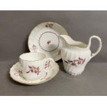 A Worcester coffee cup, saucer, milk jug and another saucer circa 1790 with puce floral sprays