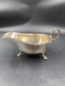 A silver sauce boat on three hoof feet by the Alex Clark Co Limited and hallmarked for Birmingham