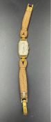 A 9ct gold ladies watch on a fabric strap