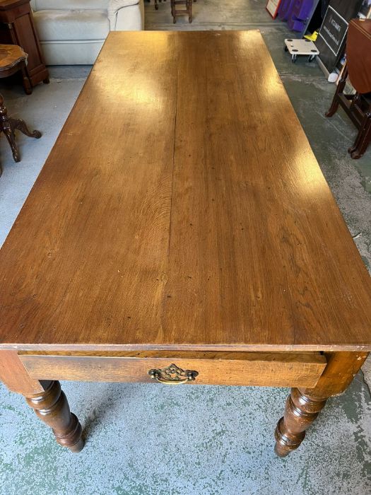A large farmhouse oak table with turned legs and drawers to each end (H78cm W200cm D84cm)