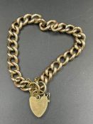A 9ct gold bracelet with heart shaped fastener and safety chain