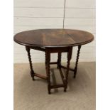 An oak oval gate leg table (H74cm W92cm D60cm)