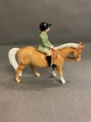A Beswick figure of a horse with young rider.
