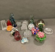 A large selection of various glass paperweights