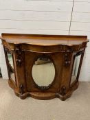 A credenza sideboard with mirrored front and carved foliage with acorns to corners (H89cm W137cm