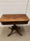 A Regency style fold over tea table on out swept legs with brass paw feet (85cm x 43cm 74cm)