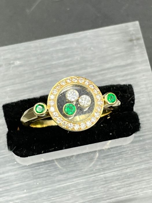 A Contemporary ring with floating diamonds and emeralds (Approximate Size N 1/2)