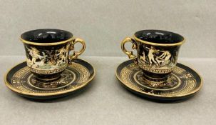 A pair of hand made in Greece coffee can and saucers, black and gold