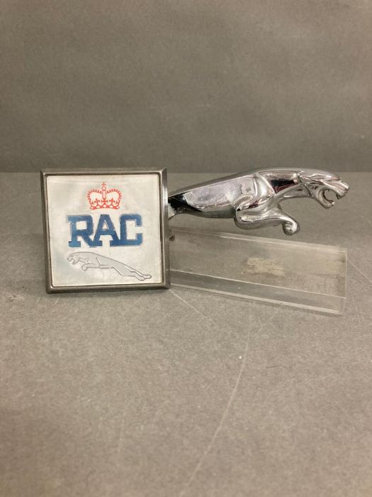 A RAC badge and mounted Jaguar car mascot