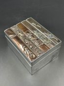 A Japanese silver cigarette box with ornate lid.