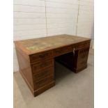 A large Victorian style mahogany pedestal desk with brass swan handles and leather top (H80cm W152cm