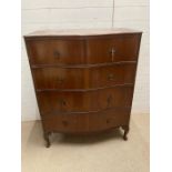 A serpentine oak chest of drawers (H118cm W63cm D47cm)