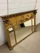 A regency style giltwood and gesso over mantle mirror with breakfront cornice with a relief