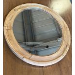 An oval pine wall mirror (62cm x 52cm)