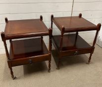 A pair of mahogany tiered side tables with drawer and castors