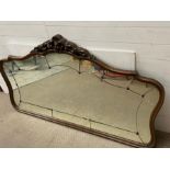 A Victorian large over mantel mirror with panelled glass edge, brass button detail and foxed