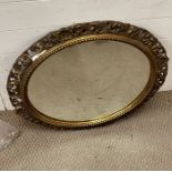 A gilt circular scrolled framed mirror