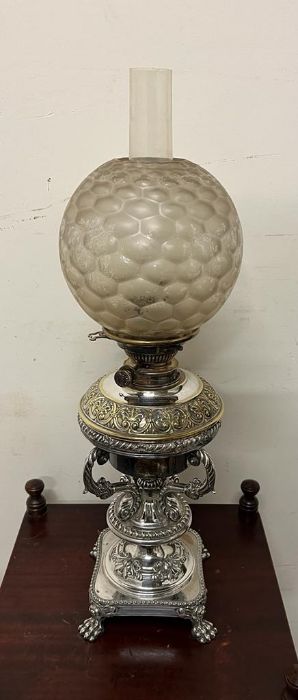 An oil burner messenger lamp with golf ball style glass shade and white metal stand