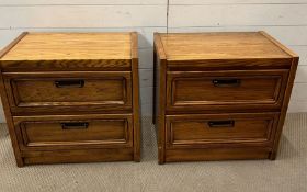 A pair of oak bedsides with two drawers and antiques brass style handles (H60cm W64cm D43cm)