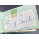 An autograph book with four signatures including Louis Armstrong