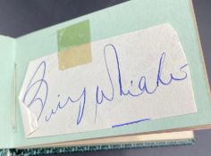 An autograph book with four signatures including Louis Armstrong