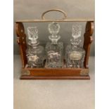 An oak lockable tantalus with three lead crystal decanters