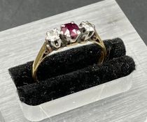 A 9ct gold ring with ruby with ruby and diamond side stones Size L 1/2