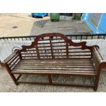 A teak slatted garden Lutyens style bench with scrolled ends and sloping arches