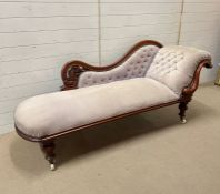 A Victorian chaise longue, mahogany frame with carved scroll detail on castors (H85cm W200cm D75cm)