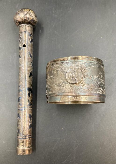 A white metal napkin ring engraved with Roc Amadour and a white metal parasol handle