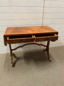 A sofa table with drop ends, drawers to centre on out swept legs (H66cm W58cm D42cm)