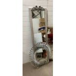 A metal circular mirror with twisted boarder and a floor standing mirror