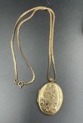 A 9ct gold oval engraved locket on a 9ct gold chain (Total weight approximately 25.7g)